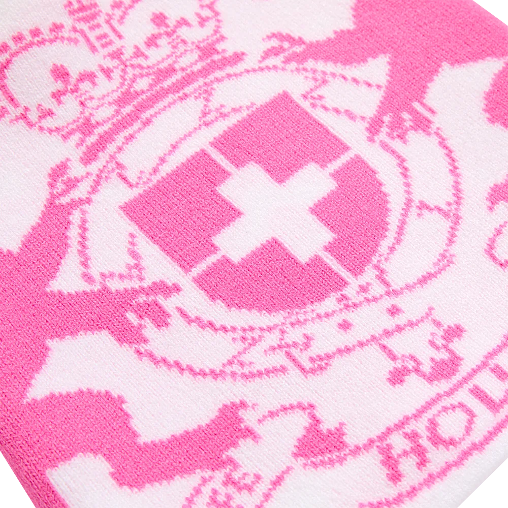Close-up of pink knit: a heraldic crest with a crown, fleurs-de-lis and a shield bearing a white cross